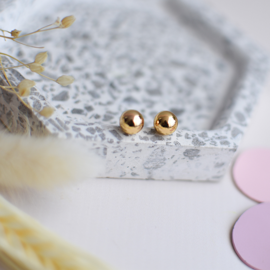 aretes de acero en forma de bola bañado en oro